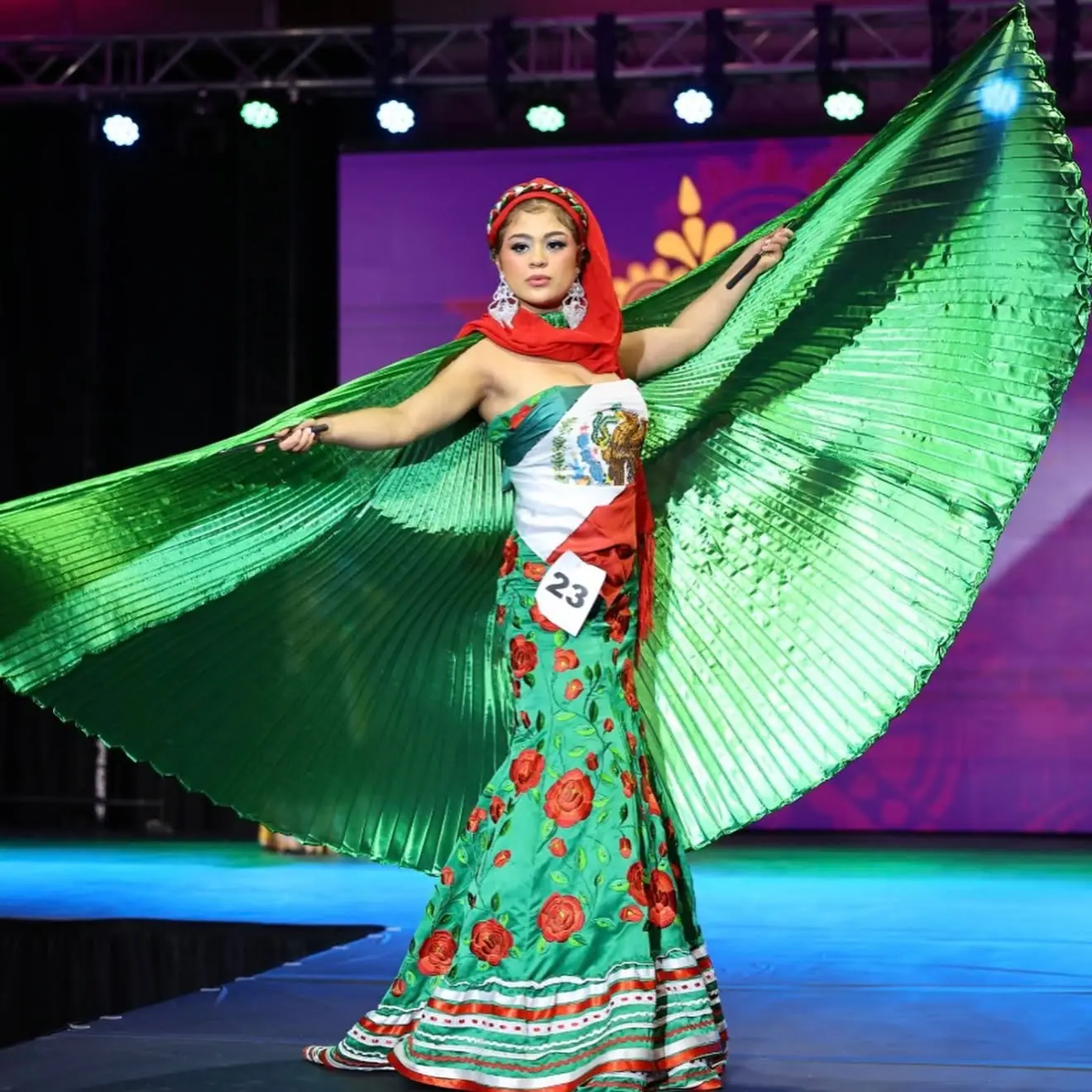 A contestant in a Mexican-inspired national costume with green wings