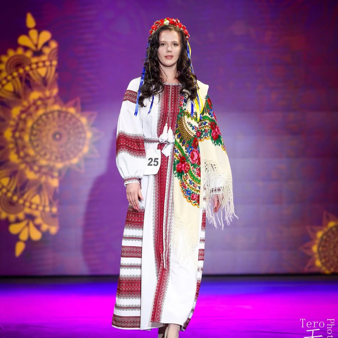 A contestant in a traditional embroidered dress and floral crown