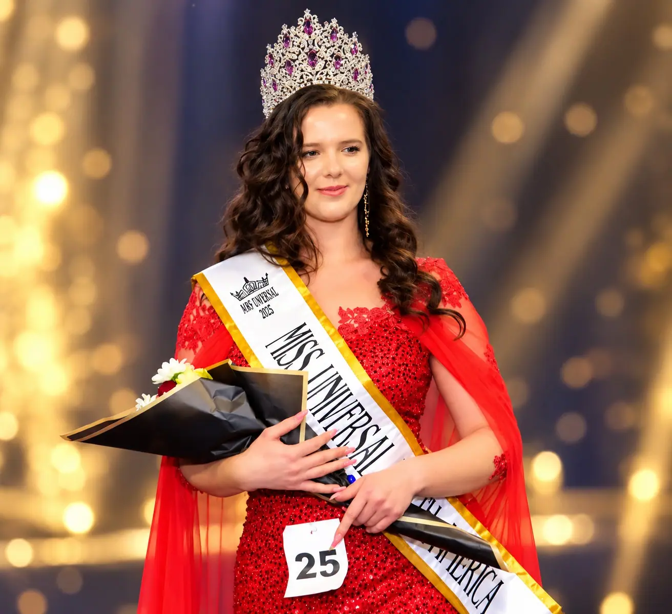 A newly crowned Miss Universal titleholder holding flowers on stage
