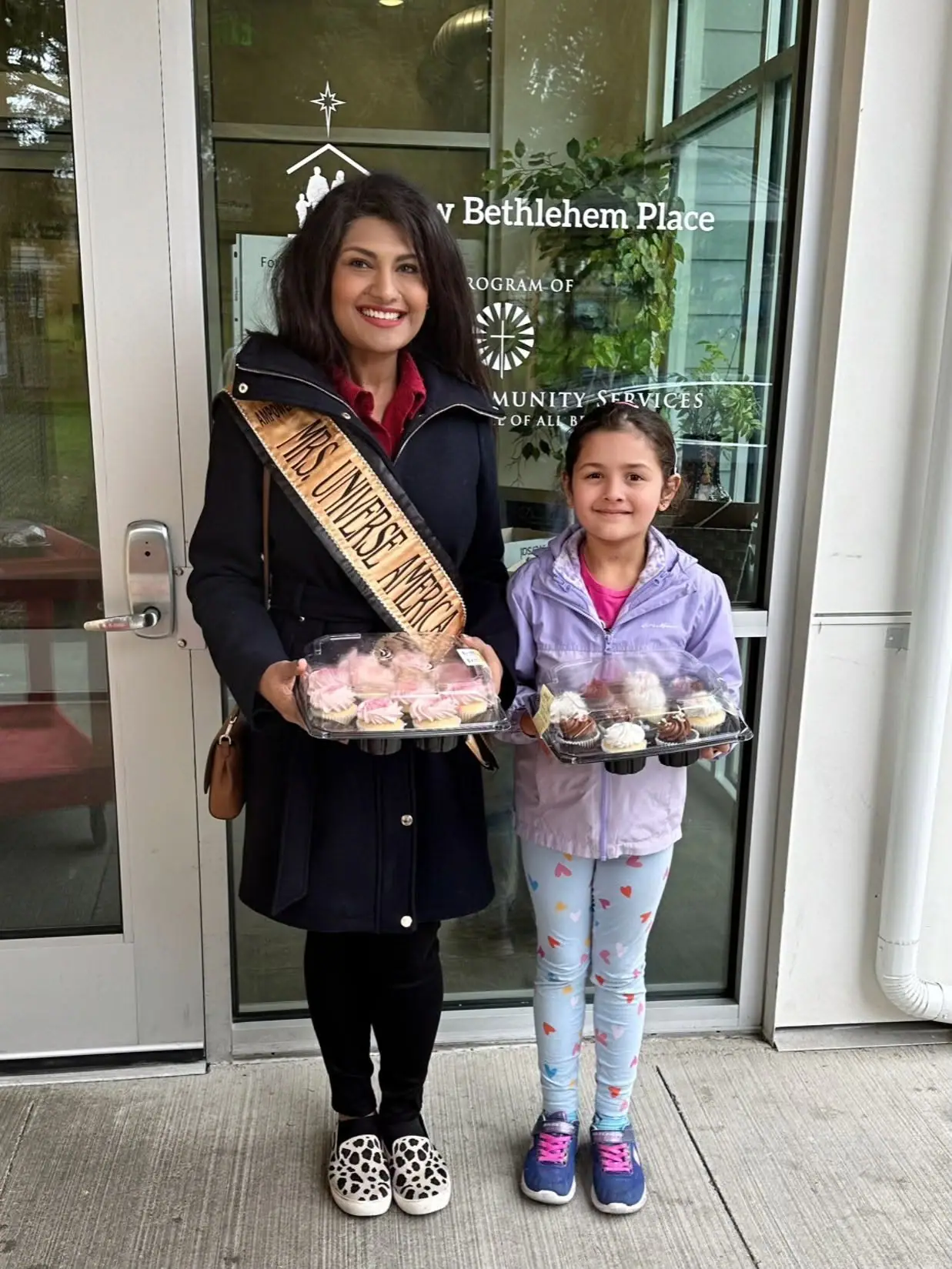 Mrs Universe America and a young volunteer delivering treats to New Bethlehem Place