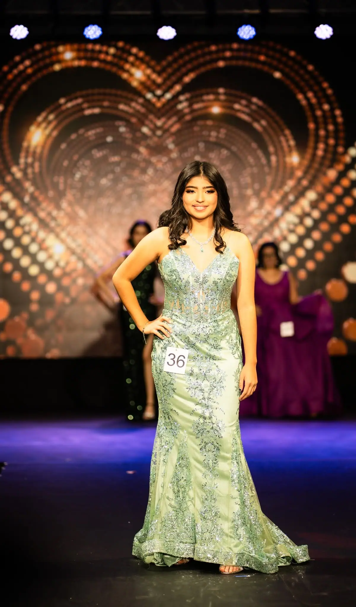 A contestant walking the stage in an evening gown