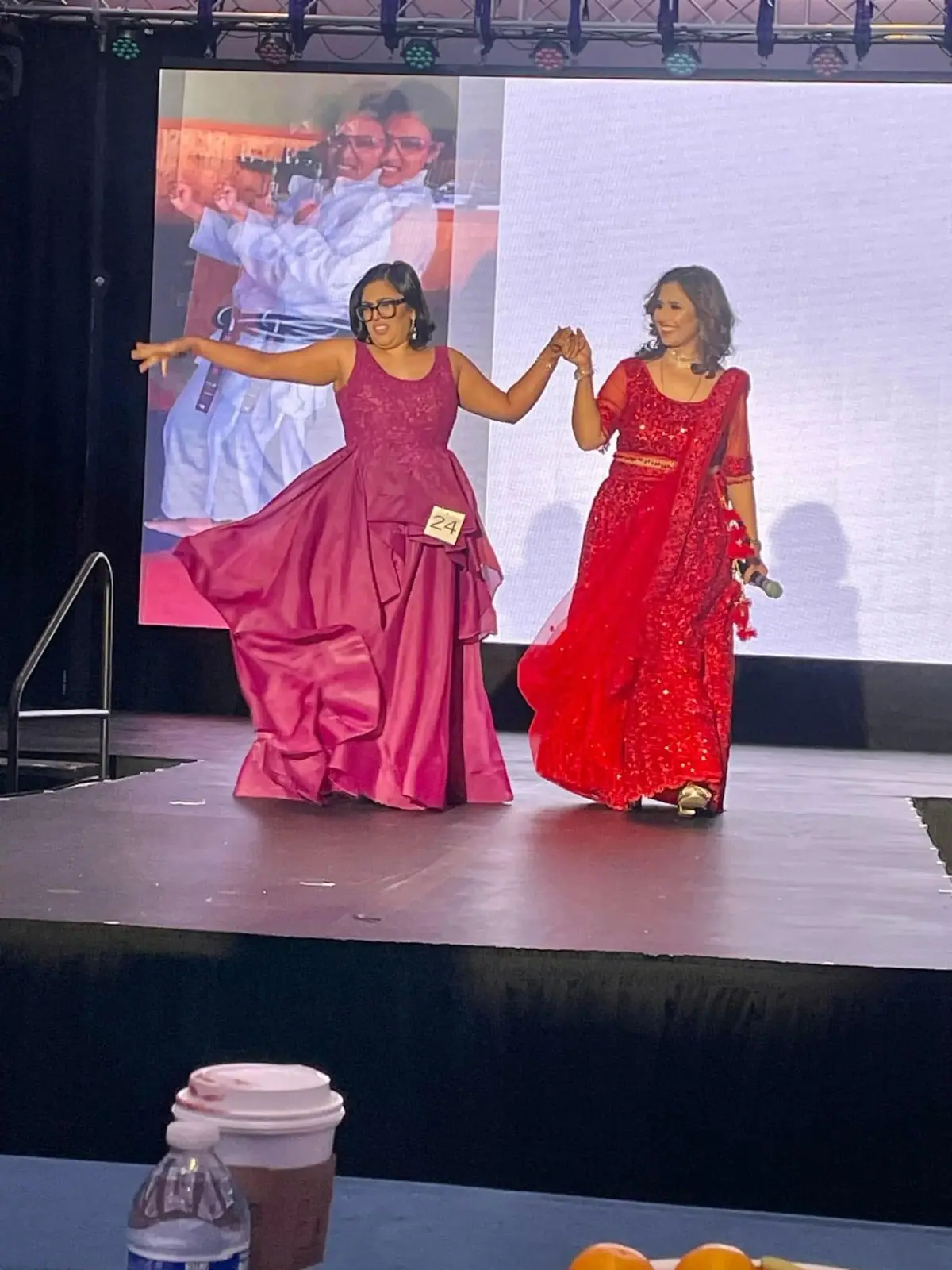 A 2024 honoree walking the stage hand in hand with the host