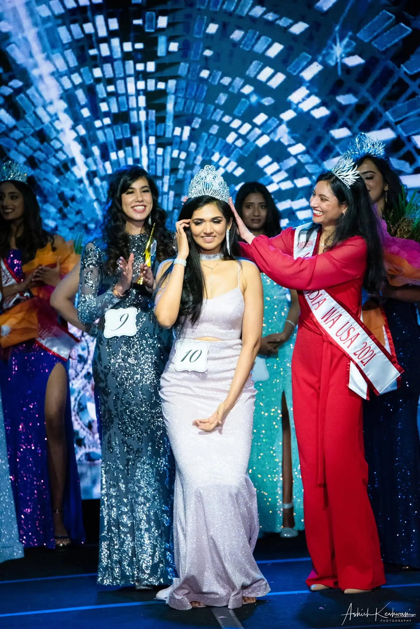The India WA USA 2021 titleholder crowning her successor on stage as the contestants applaud