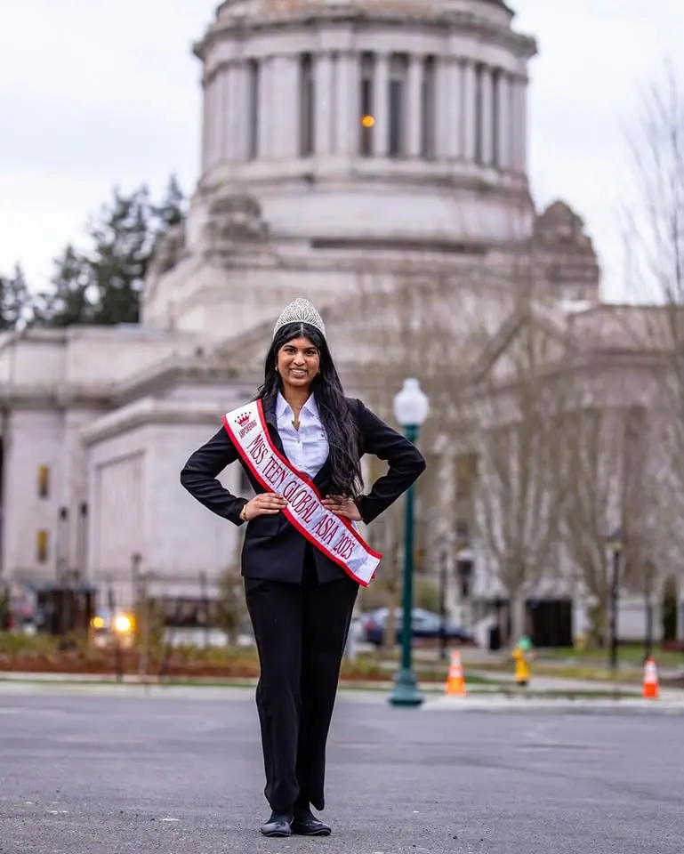 Miss Teen Global Asia 2023 in her crown and sash in front of the Washington State Capitol