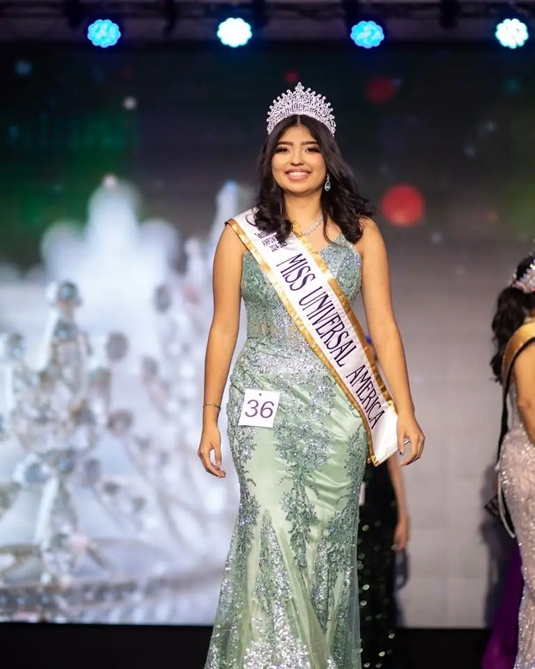 A Miss Universal titleholder in a green gown on stage