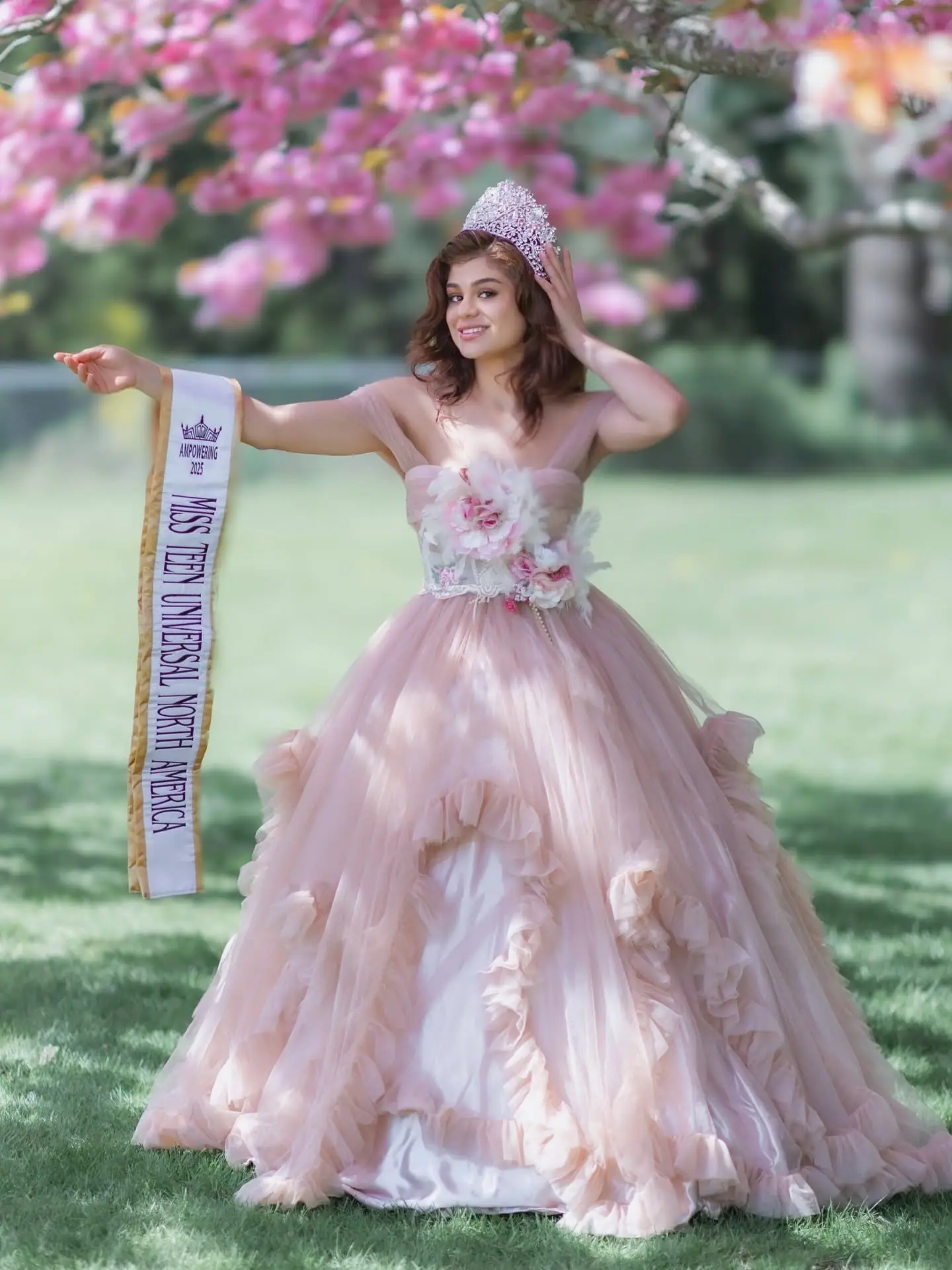Miss Teen Universal North America in a pink gown in a garden